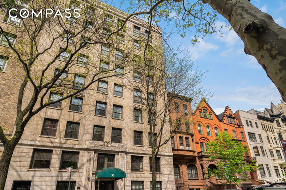 Front view of a multi-story building with a decorative facade and an entrance canopy.