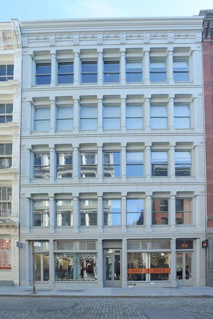 Front view of a multi-story commercial building with large windows and a storefront on the ground floor.