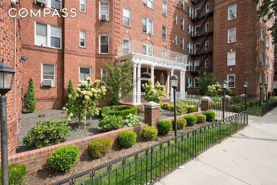 Front view of a multi-story brick building with ornamental entrance columns.