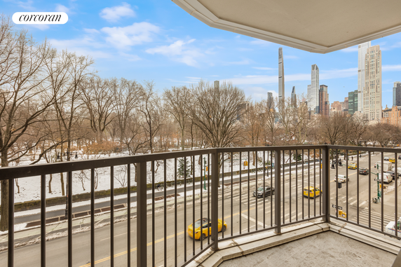 View of city skyline and park from a balcony.
