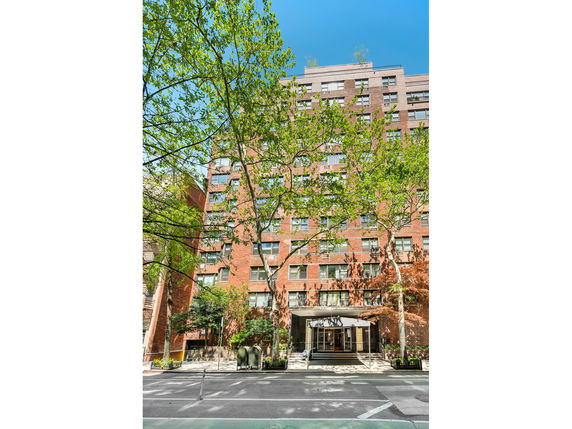 Front view of a multi-story brick building with large windows and a canopy entrance.