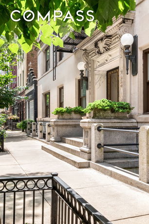 Front view of a building with decorative stonework and steps leading to the entrance.