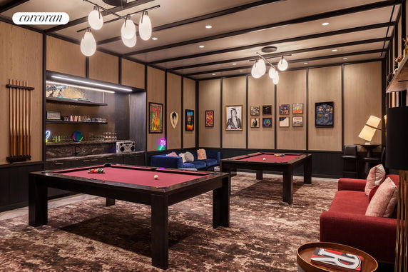 Interior view of a recreation room with pool tables and seating area.