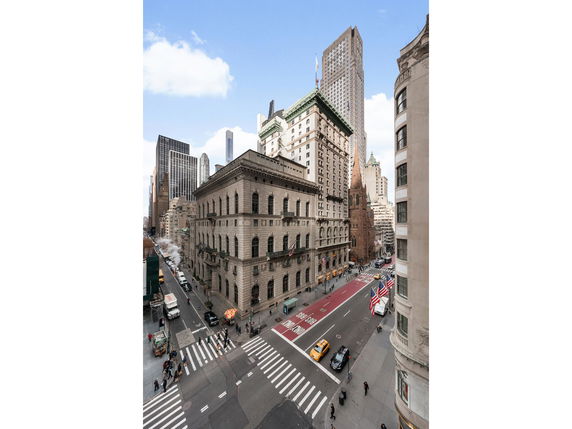 Front view of a multi-story historic building on a city street corner.