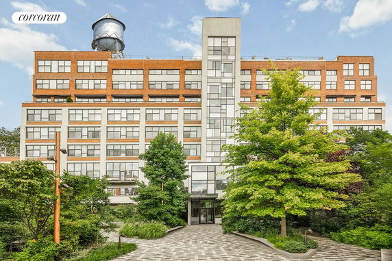 Front view of a multi-story building with a water tower on the roof.