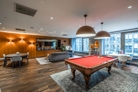 Interior view of a recreational room featuring a pool table, cozy seating, and modern decor.