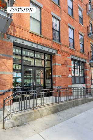 Front view of a brick building with large glass doors and windows.