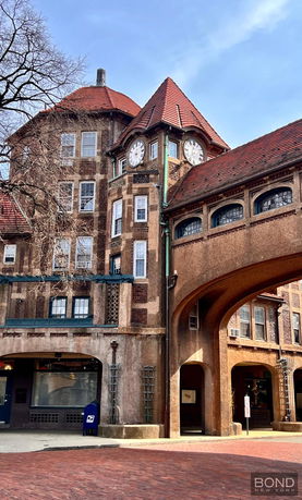 Front view of a historic building with a clock tower and arched entrance.