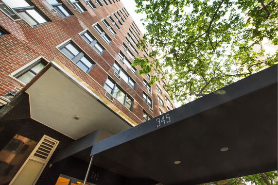 Front view of a multi-story brick building with canopies.