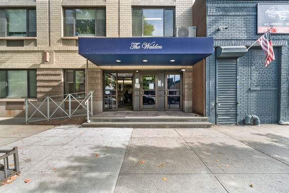 Front view of a building entrance with a blue canopy labeled 'The Walden.'