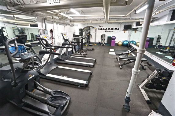 Indoor gym area with exercise equipment and mirrors.