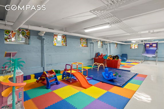 Indoor play area with colorful mats and children's play equipment.