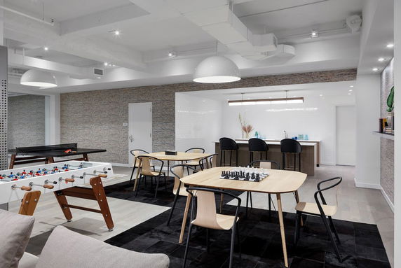 Indoor recreation room with foosball table, ping pong table, and seating area.