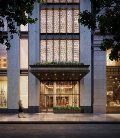 Front view of a modern building with glass entrance and decorative facade.