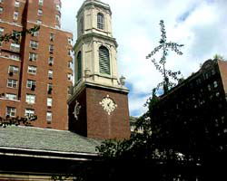 Front view of a building with a tower and clock.
