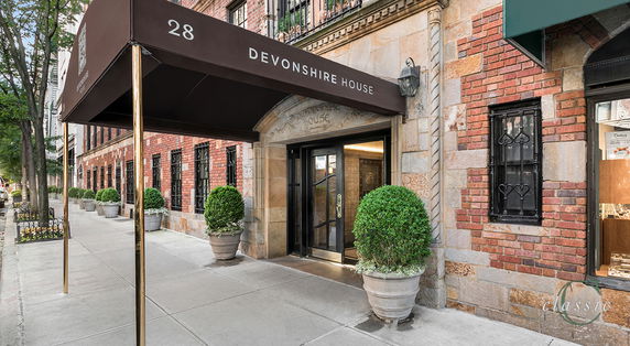 Front view of a multi-story brick building with an entrance canopy labeled 'Devonshire House'.