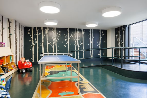 Indoor play area with a ping pong table and children's toys.