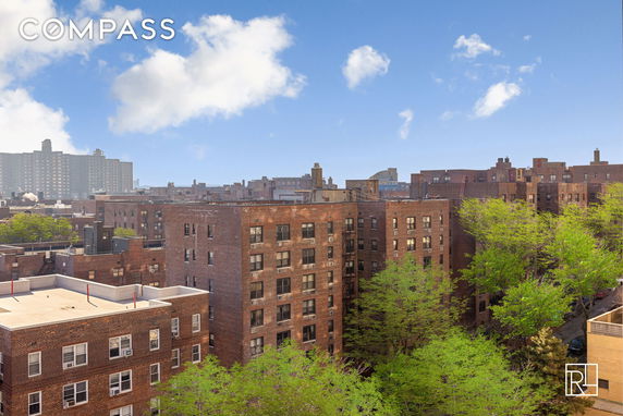 Rooftop view of multiple brick residential buildings with visible trees around.