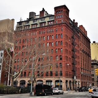 Front view of a multi-story brick building on a city corner.