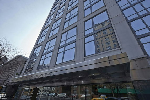 Front view of a multi-story building with large windows and a steel canopy.