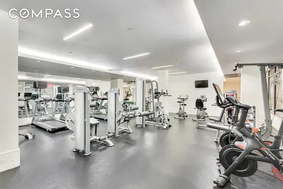 Indoor gym area with exercise equipment and mirrors.