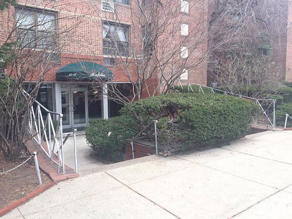 Front view of a multi-story brick building with a covered entrance.
