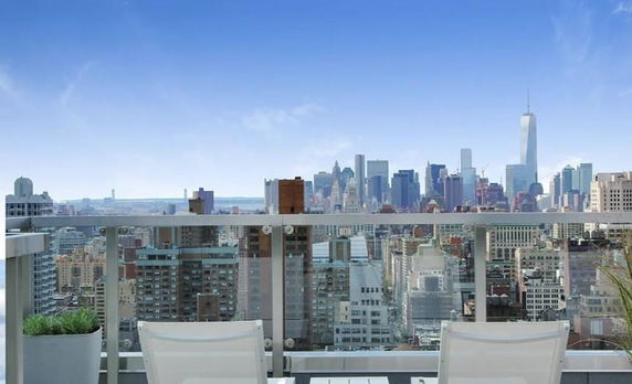 Panoramic view of a city skyline from a rooftop terrace.
