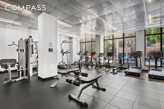 Indoor gym area with exercise equipment, including treadmills, bikes, and weight machines.