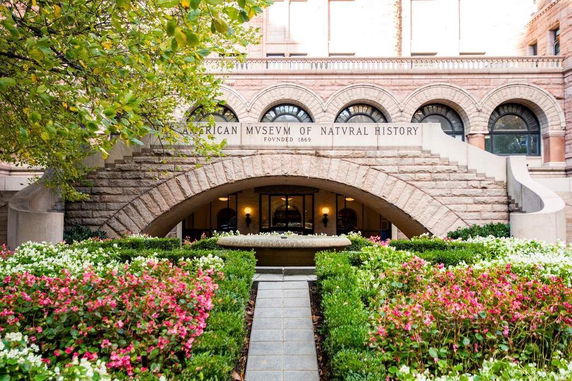 Front view of a historic building with arched windows and a stone archway entrance.