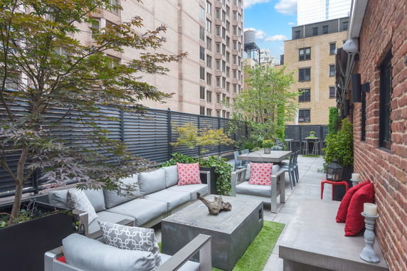 Rooftop with outdoor seating, dining area, and decorative plants.