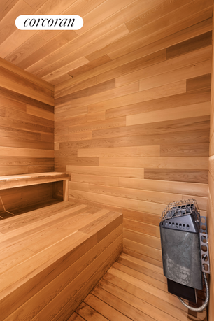 Interior view of a wooden sauna with a bench and a heater.