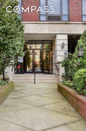 Front view of a building entrance with glass doors and steps.