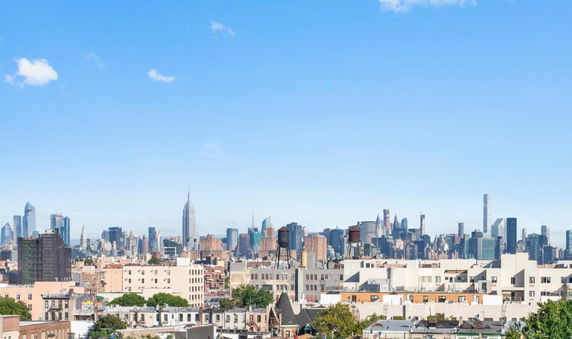 View of a city skyline with buildings and skyscrapers under a clear blue sky.
