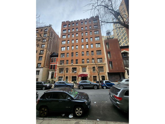 Front view of a multi-story brick building in an urban area.