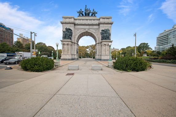 Front view of a historic arch monument with sculptures and inscriptions.