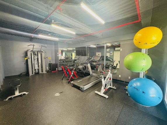 Interior view of a gym with exercise machines and equipment.