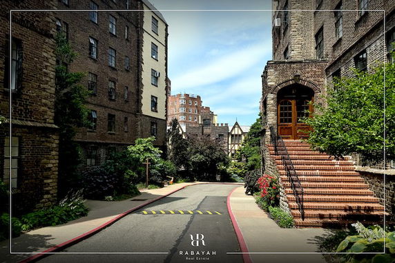View of surrounding buildings along a narrow street with a staircase leading to a building entrance.