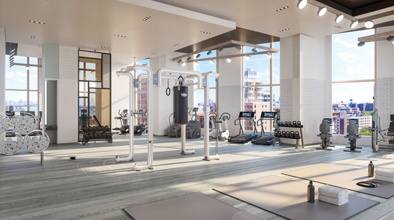 Modern indoor gym with exercise equipment and large windows.