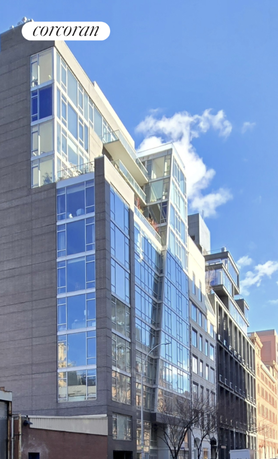 Front view of a modern multi-story building with large glass windows.