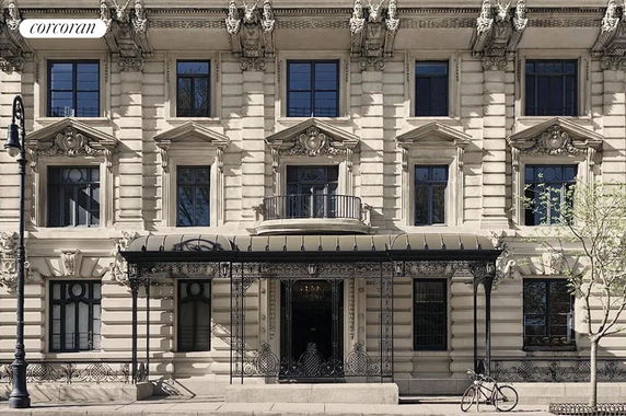 Front view of an ornate multi-story building with decorative architectural details and wrought iron accents.