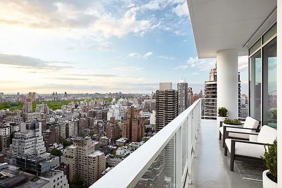 Panoramic view from a balcony overlooking a city skyline.