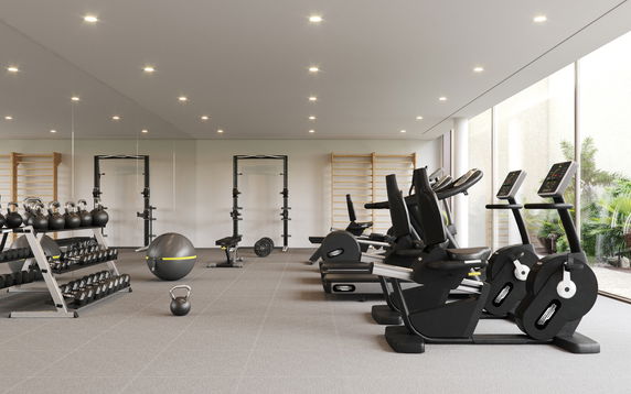 Indoor gym area with exercise equipment and large windows.