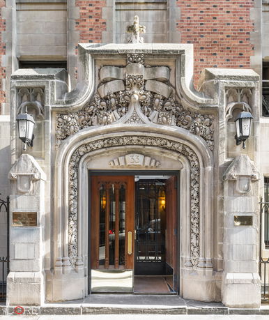 Front view of an ornate stone building entrance with intricate architectural details.