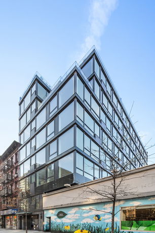 Front view of a modern multi-story building with large glass windows.