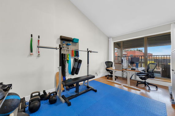 Room with exercise equipment and office desk setup