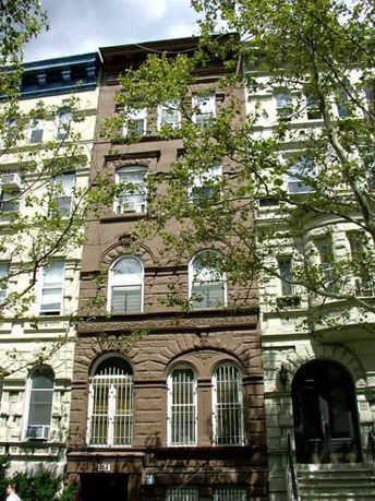 Front view of a multi-story building with arched windows and decorative stonework.