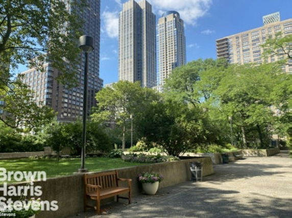View of surrounding area with tall buildings and trees in a park-like setting.