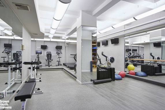 Indoor fitness area with exercise equipment and mirrors.