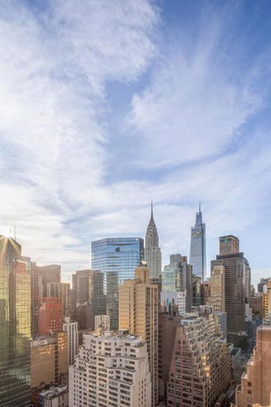 Panoramic view of a city skyline with tall buildings and a clear sky.