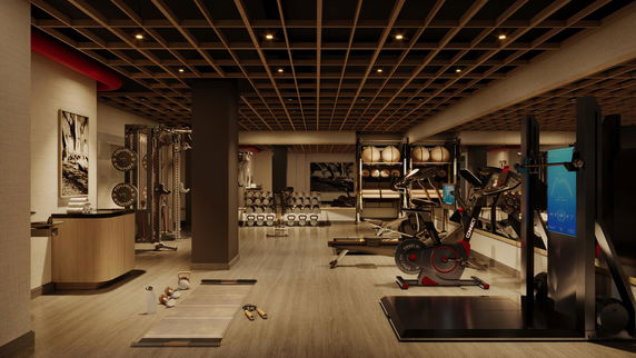Interior view of a modern gym with exercise equipment and weights.